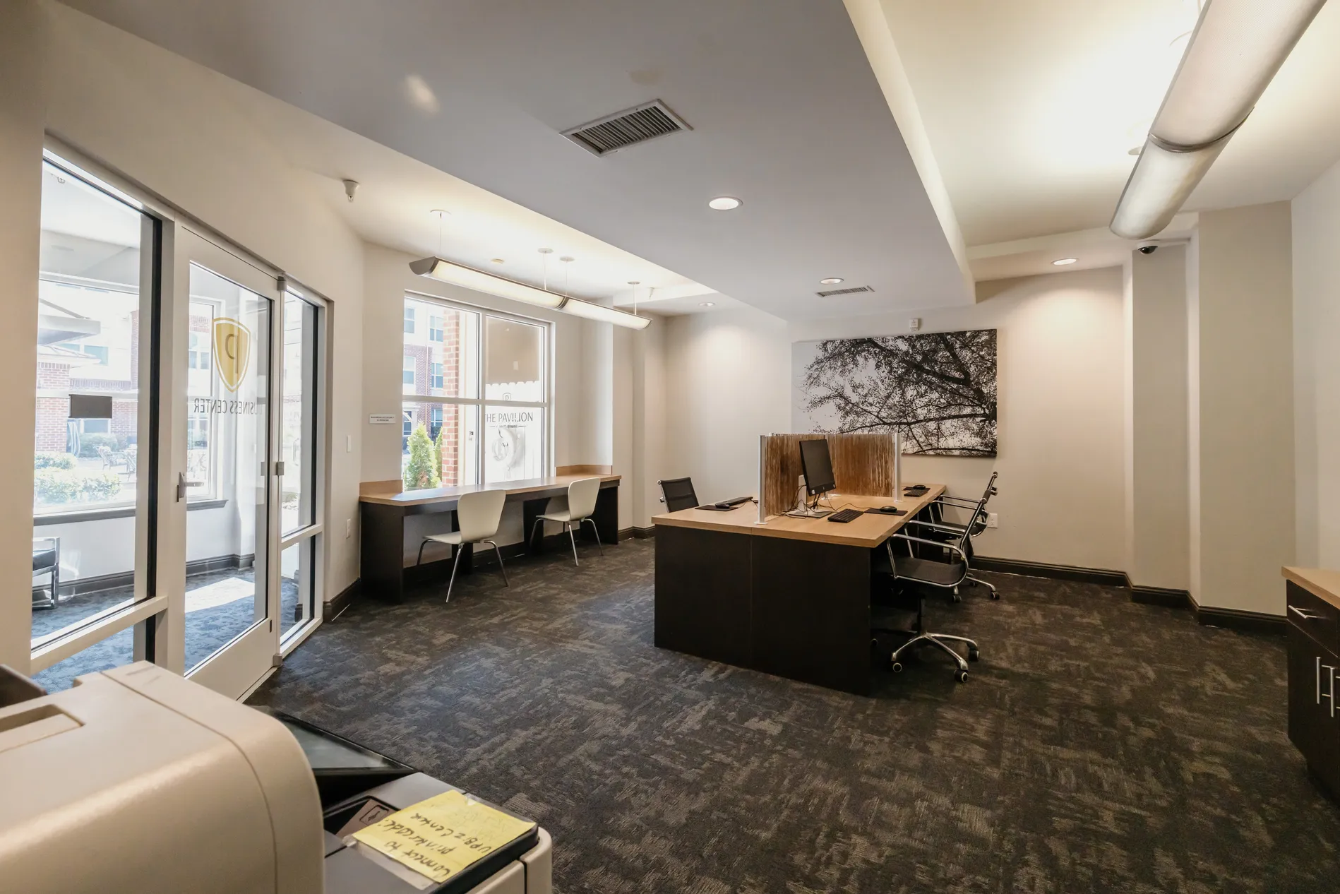 Business center with a printer, workstations and a large desk