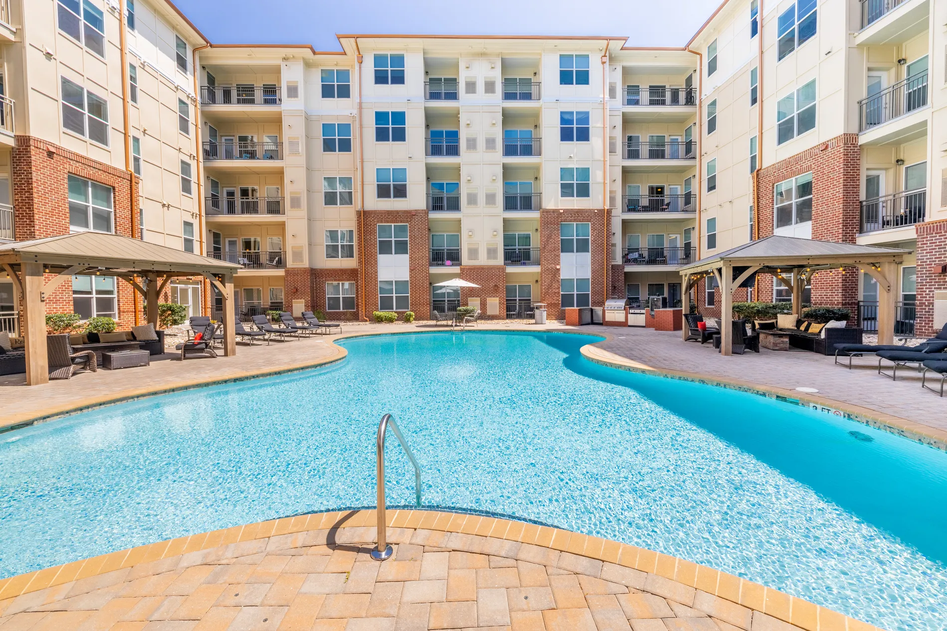 Resort-style pool with shaded cabanas in the central courtyard