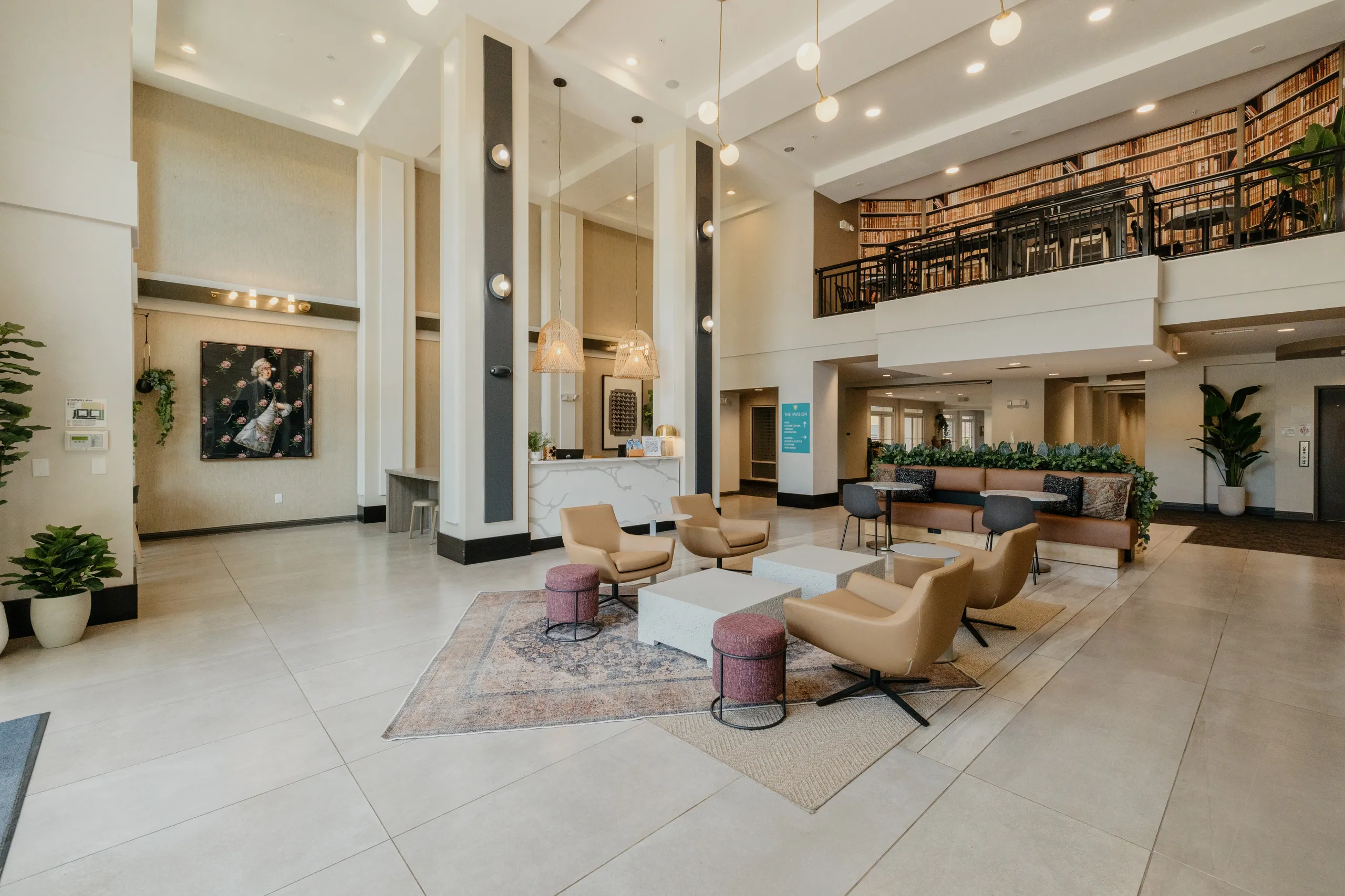 Two-storey lobby with lounge seating beneath a library mezzanine