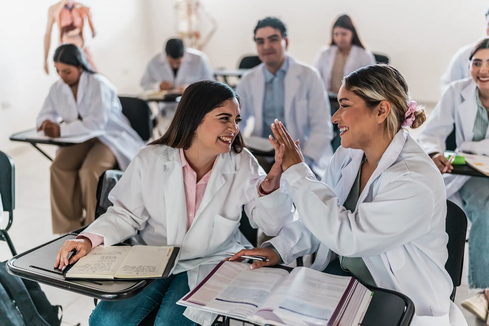 Young medical students women talking and stuyding during class at university